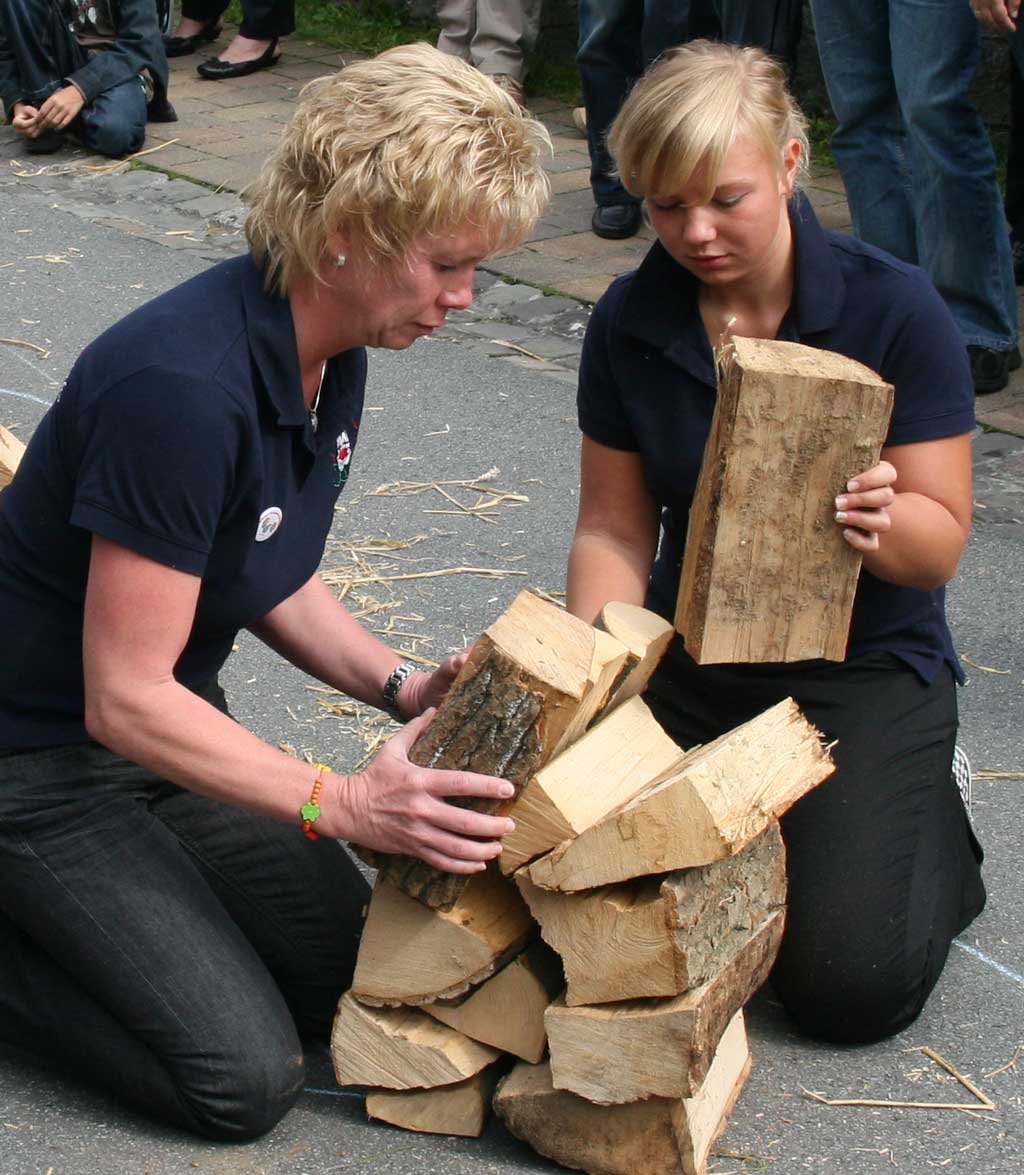 Dorfolympiade - Holzscheit-Stapeln Ria Verhufen und Lisa Drüke (von links) beim Holzscheit-Stapeln
